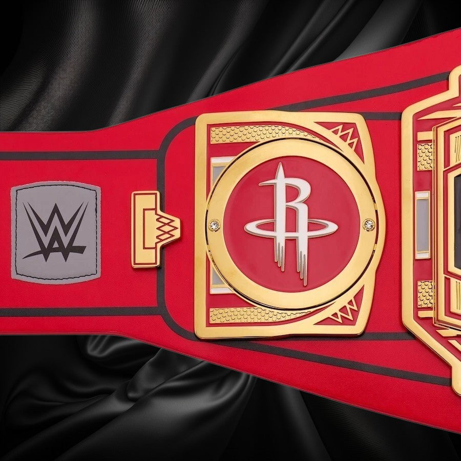 Red championship belt with gold buckle featuring a logo, on a white background
